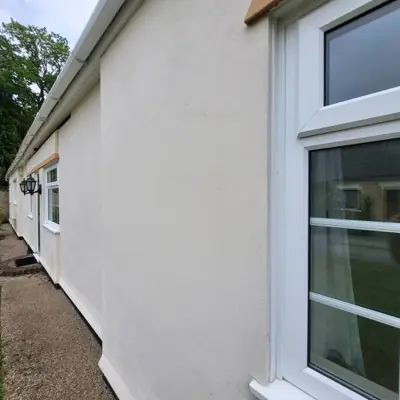 The same rendered wall after softwashing, clean and even